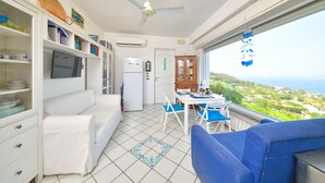 Um espaço compacto com cozinha compacta, área de refeições e sofá.