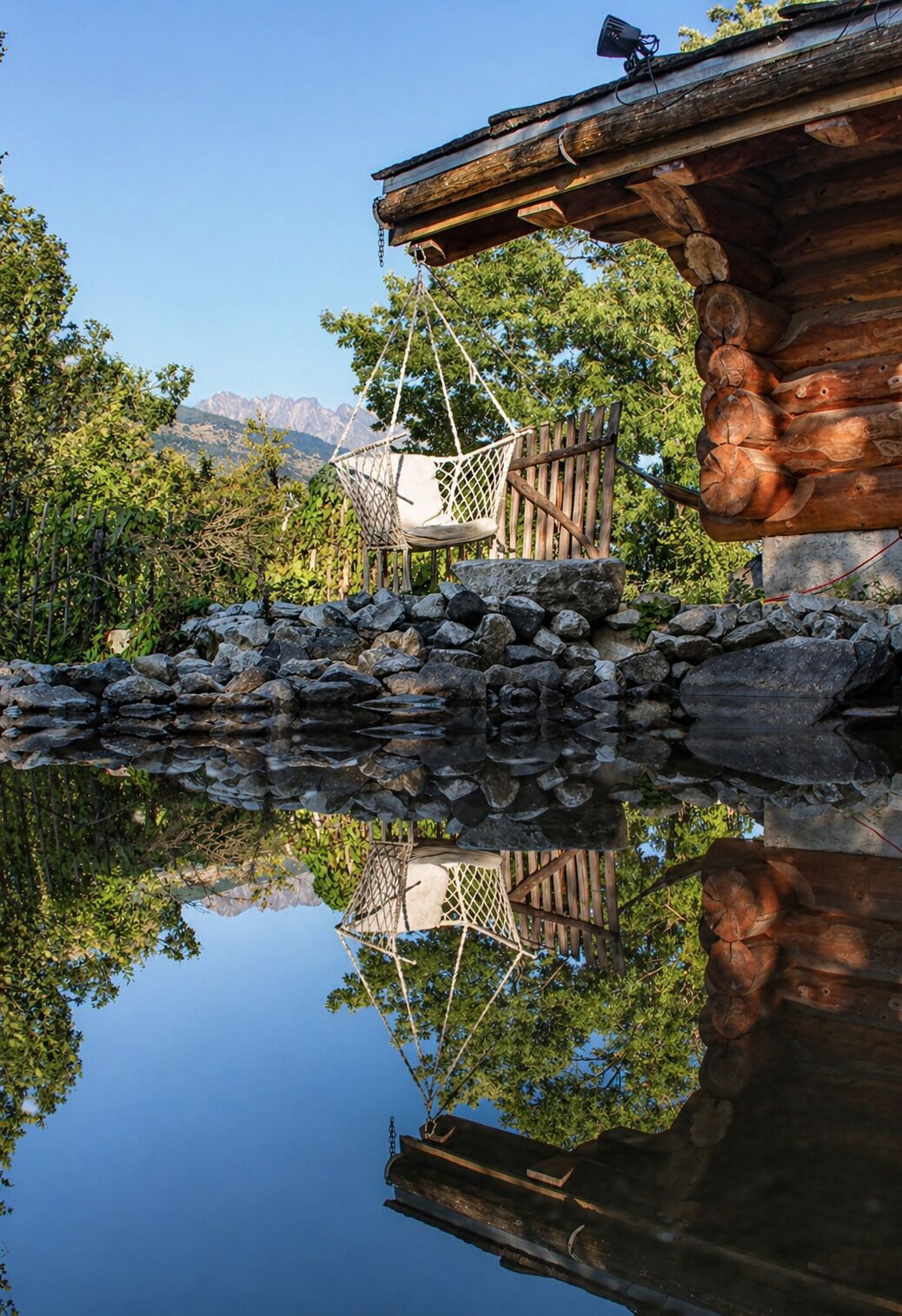 Eine Holzhütte mit Steinwand und einer Hängematte.