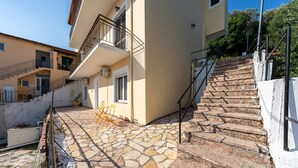 Un edificio con un patio de piedra, una escalera y un balcón.