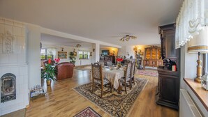 A spacious dining area with a large wooden table, surrounded by chairs, and a fireplace. - Willa Sun & Snow Zasypane Mazury (gmina Malkinia Gorna)