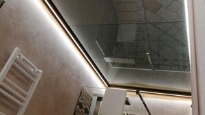 A modern bathroom with a skylight, a towel rack, and patterned tiles. - The Prince's Mansion (Trani)