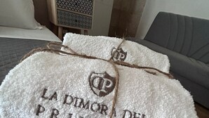 A bed with white towels tied with a string, each towel embroidered with "LA DIMORADA DEL PRINCIPE". - The Prince's Mansion (Trani)
