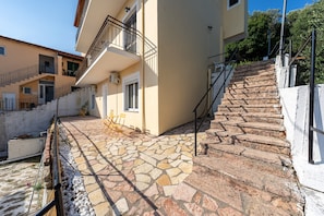 Um edifício com um pátio de tijolos, uma escadaria e uma varanda.