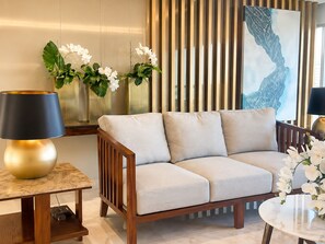 Una sala de estar moderna con un sofá, una lámpara, una mesa y plantas decorativas.