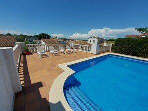 A swimming pool with sun loungers and a tiled deck. - Casa Sol with private pool and free wifi (L'Escala)