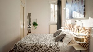 A bedroom with a bed, bedside table, and a window with curtains. - Accomodo MIM21 Monolocale Porta Venezia (Milan)