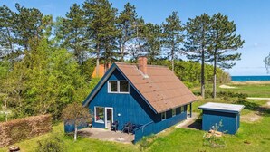 A single-story blue house with a gabled roof, a chimney, and a small attached shed. - "Naina" - 200m from the sea by Interhome (Grenaa)