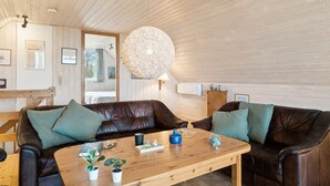 A cozy living room with two leather sofas, a wooden coffee table, and a large, round, textured ceiling light. - "Naina" - 200m from the sea by Interhome (Grenaa)