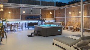 A hot tub with a wooden deck, lounge chairs, and a table with chairs. - Porfyra Suite 1 (Agistri)