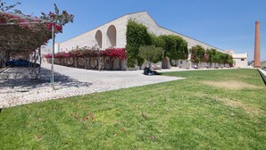 Un bâtiment doté d’une façade en pierre, de fenêtres en arc de cercle et d’une cheminée.