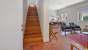 Un escalier menant à une salle à manger équipée de chaises et d’une table.