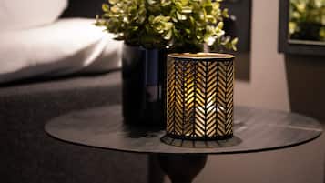 Una mesa redonda con una lámpara decorativa y una planta en maceta.