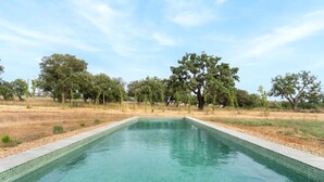 A rectangular swimming pool with clear water, surrounded by a grassy area and trees. - Holiday Home 'Monte De Santiago' with Mountain View, Private Pool and Wi-Fi (São Domingos)