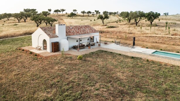 A white building with a tiled roof, a pool, and a grassy landscape with trees. - Holiday Home 'Monte De Santiago' with Mountain View, Private Pool and Wi-Fi (São Domingos)