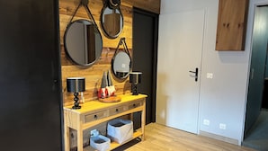 A modern room with a wooden wall, a wooden cabinet, a door, and a mirror. - Apartment: Chez Pierre (Courchevel)