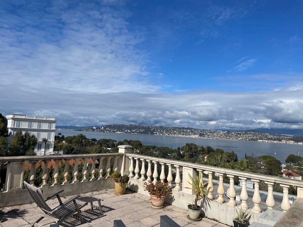 A balcony with a view of a cityscape and a body of water.