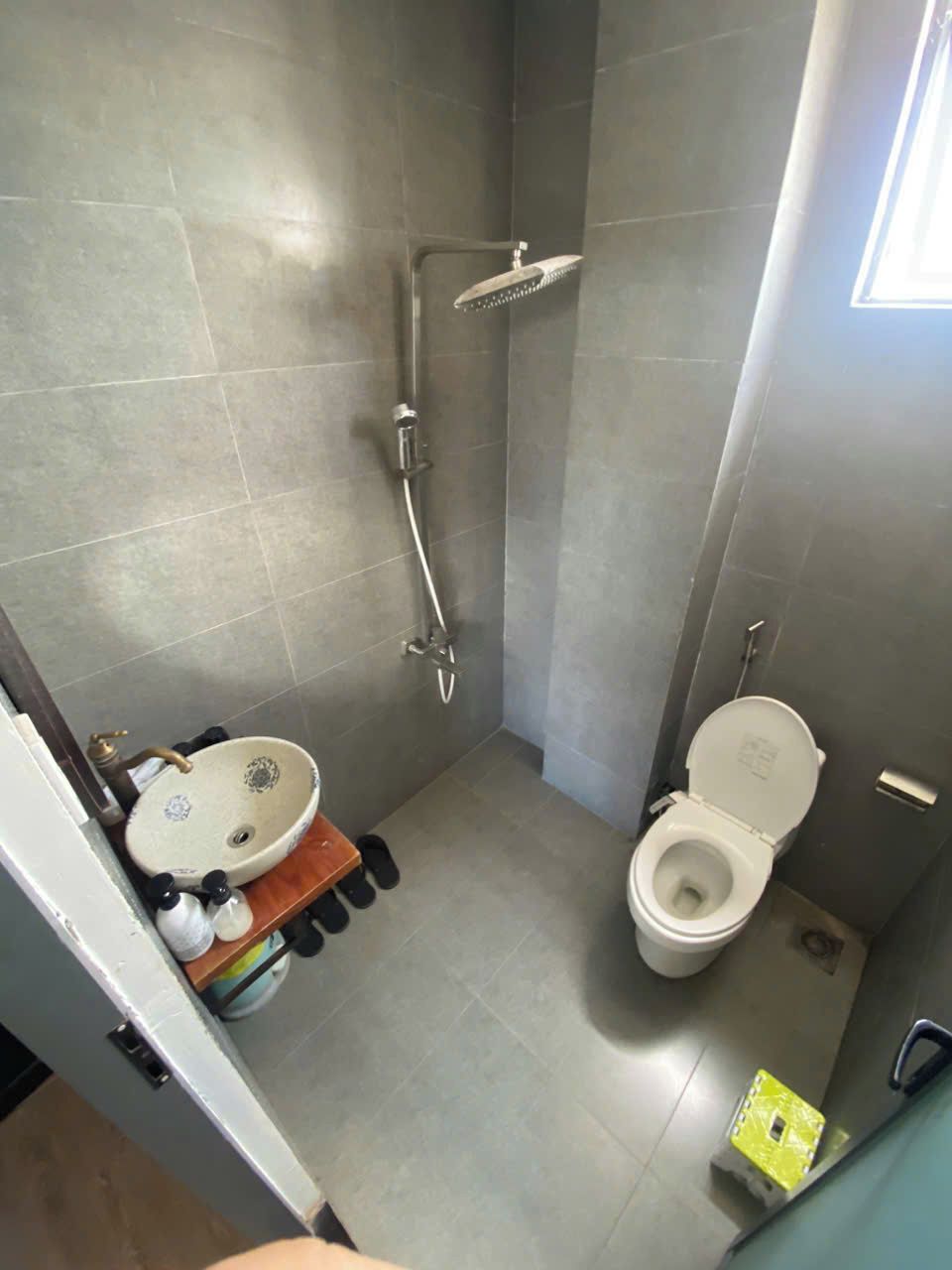 A small bathroom with a sink, toilet, and shower.