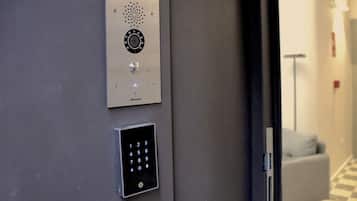 A wall-mounted elevator control panel with a numeric keypad and a circular interface.