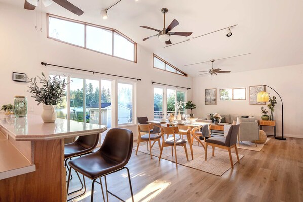 Una cocina amplia con una isla central, sillas de madera y una mesa de comedor.