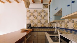 A compact kitchen with a wooden countertop, a sink, a microwave, and patterned backsplash tiles. - Castelar Suite, Villajoyosa Old Town, Seaview (La Vila Joiosa)