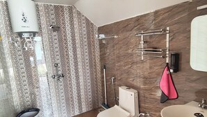 Een badkamer met toilet, bidet, wastafel en handdoekrek.