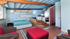 Un dormitorio con una cama, una escalera de madera y una kitchenette.