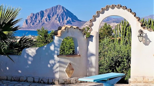 Zona de piscina con vistas a una montaña y cielo despejado.