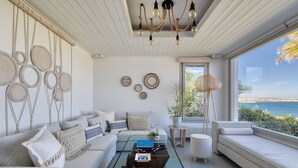 Ein modernes Wohnzimmer mit einer Couch, einem Couchtisch und Blick auf das Meer.
