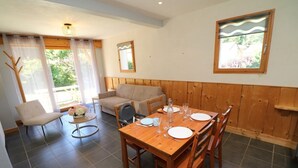 Een eethoek met een houten tafel voor vier personen, een bank en een stoel.