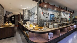 Una mesa de buffet con diversos alimentos y utensilios.