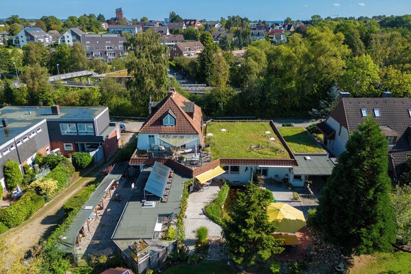 A residential area with a house featuring a sloped roof, solar panels, and a small garden. - Cozy apartment in a great central location (Scharbeutz)