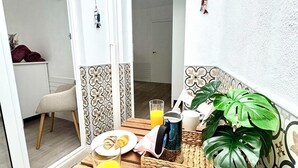 A wooden table with breakfast items including croissants, orange juice, and a coffee pot.