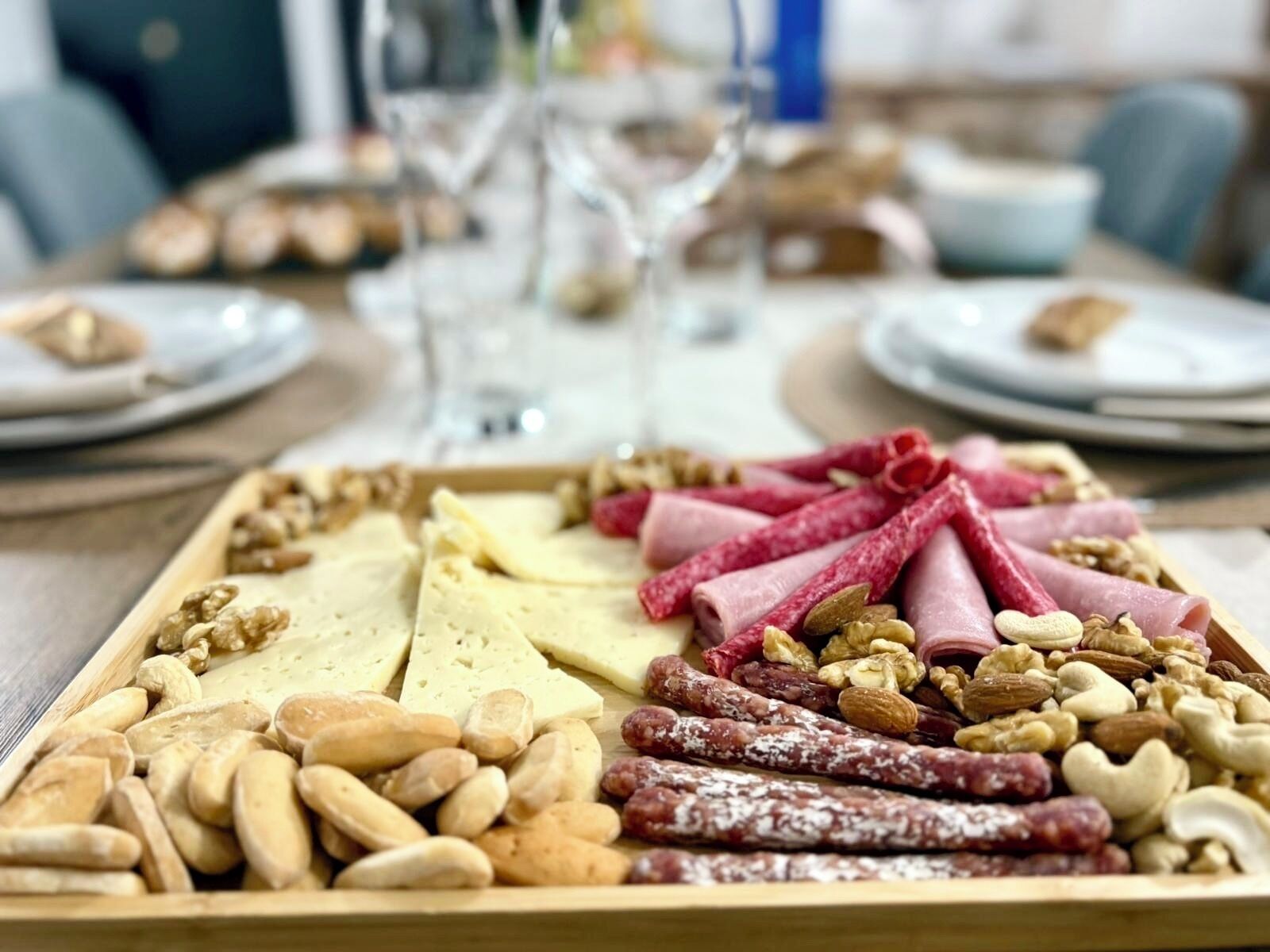 A charcuterie board with various cheeses, meats, and nuts.