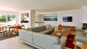 Una sala de estar moderna con sofá, mesa de centro y comedor.