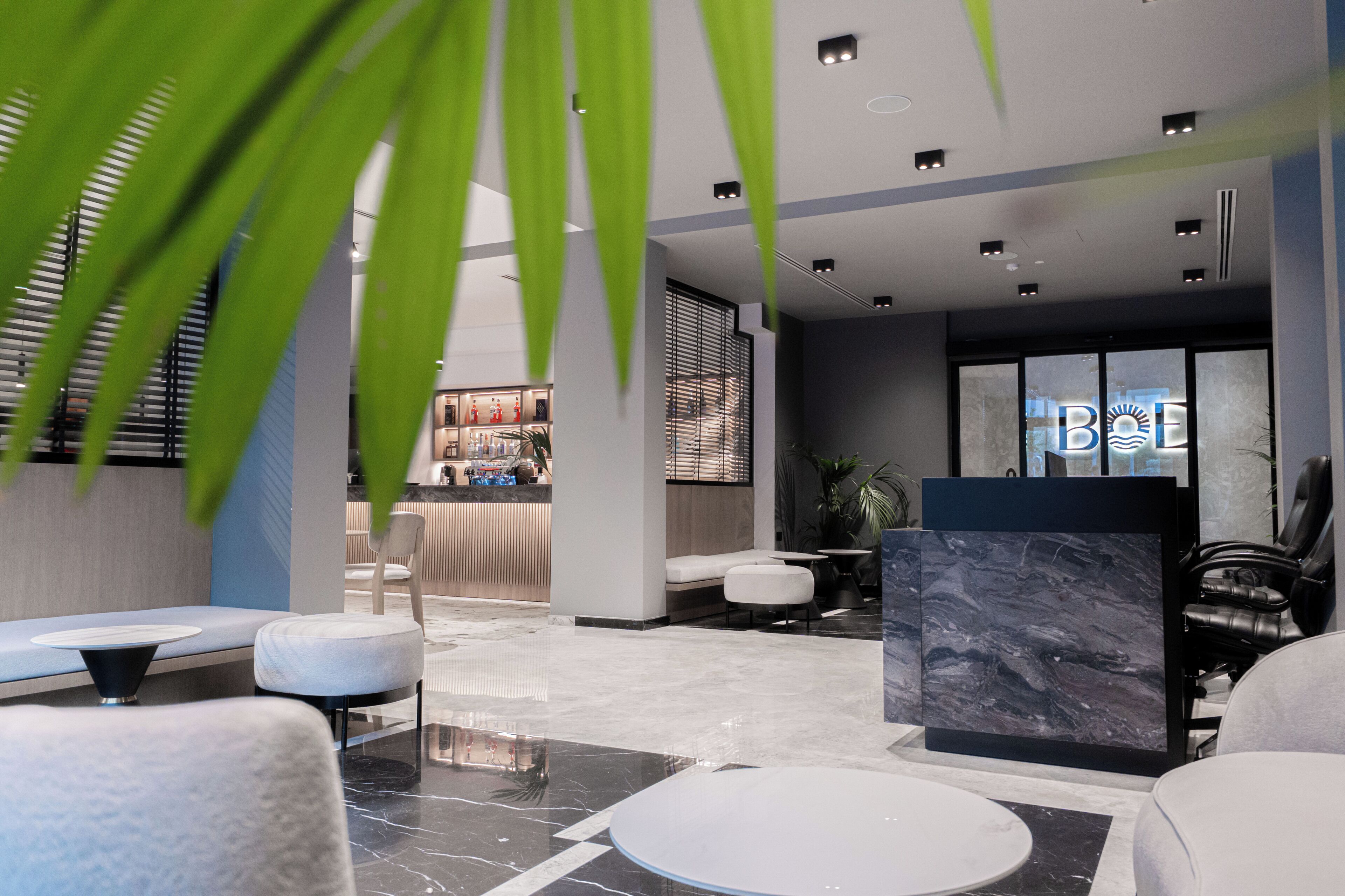 Eine moderne Lobby mit einer Rezeption, einer Sitzecke und einer großen Marmorvitrine.