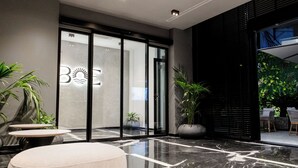 Eine moderne Lobby mit Glastür, Marmorboden und Zimmerpflanzen.