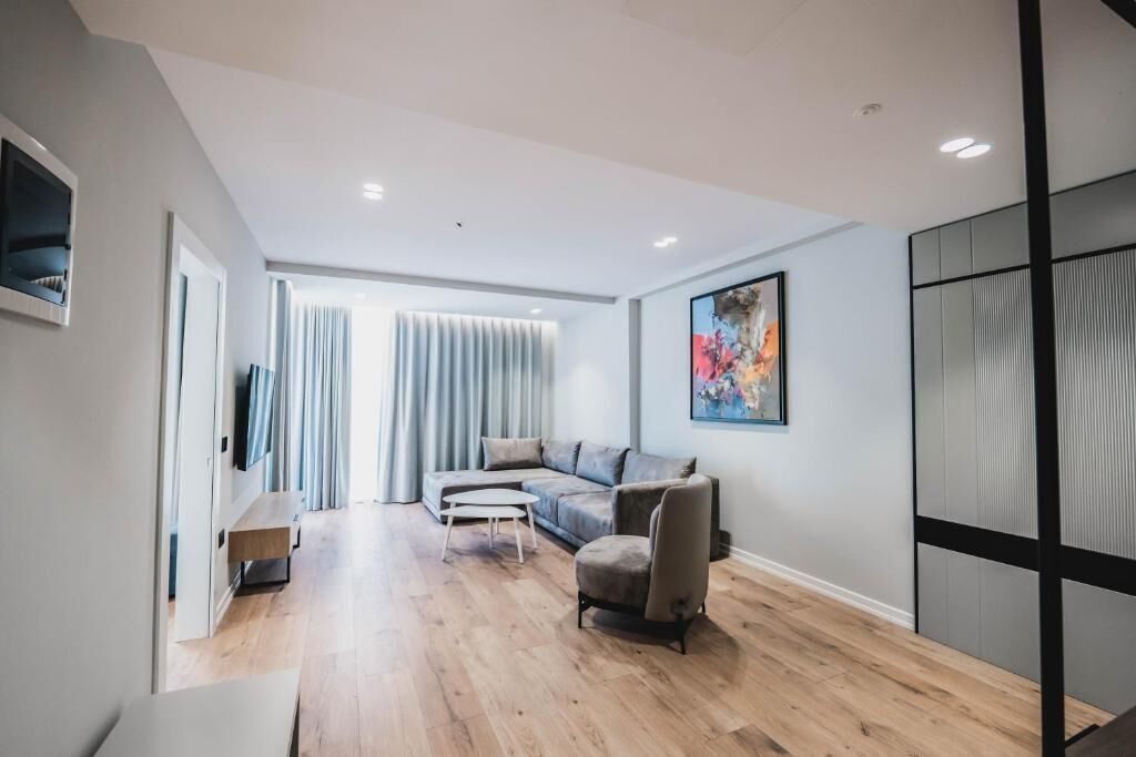 A modern living room with a sofa, armchairs, and a coffee table.