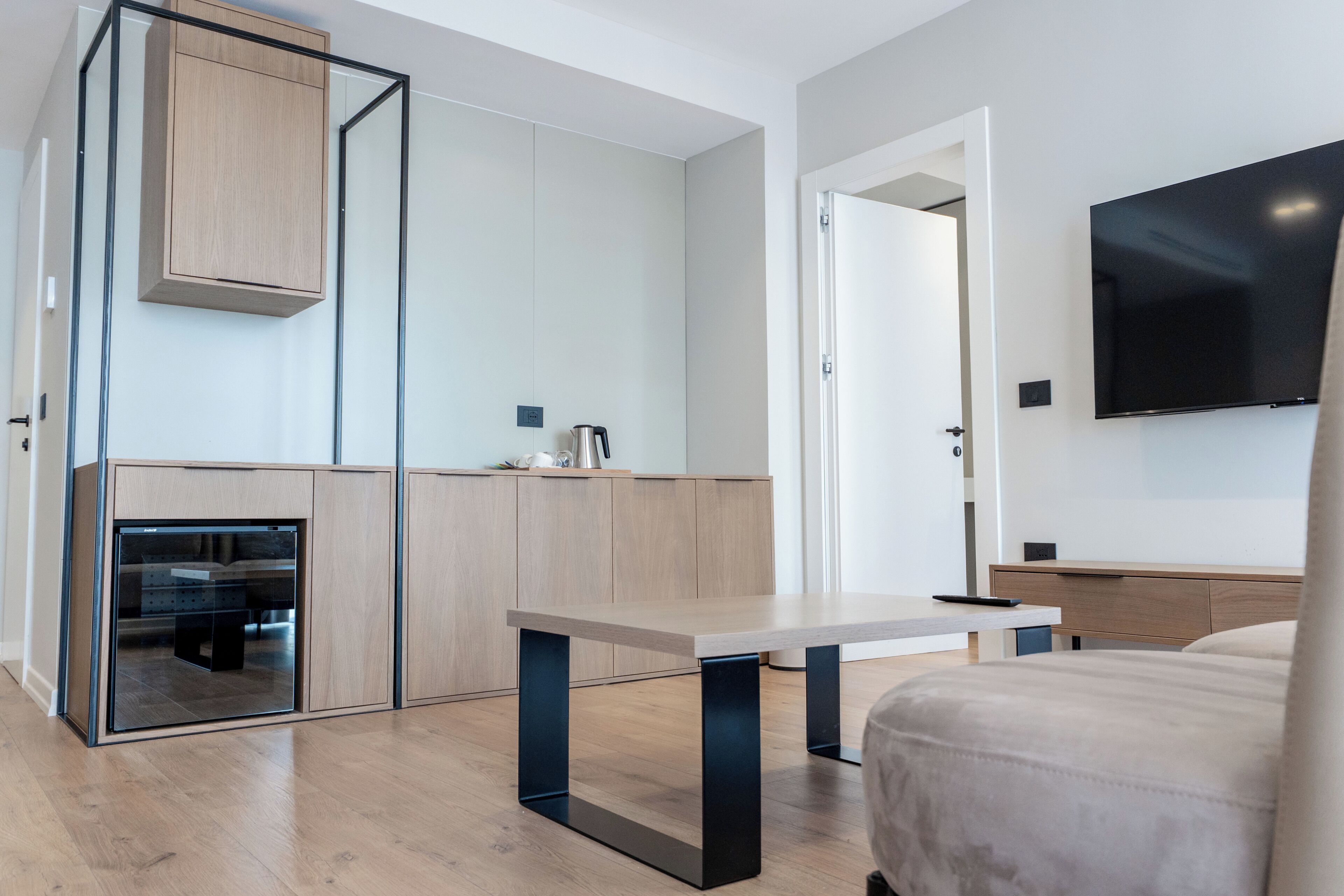 Une chambre d’hôtel moderne équipée d’un lit, d’un bureau, d’une télévision et d’une kitchenette.