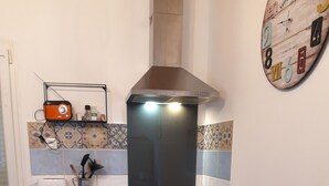 Eine Küche mit Herd, Backofen und Mikrowelle. Auf der Arbeitsfläche befinden sich ein Toaster und eine Kaffeemaschine.