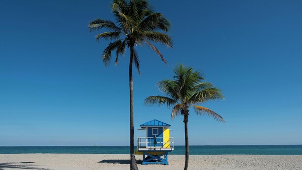 A lifeguard tower on a beach with clear skies.