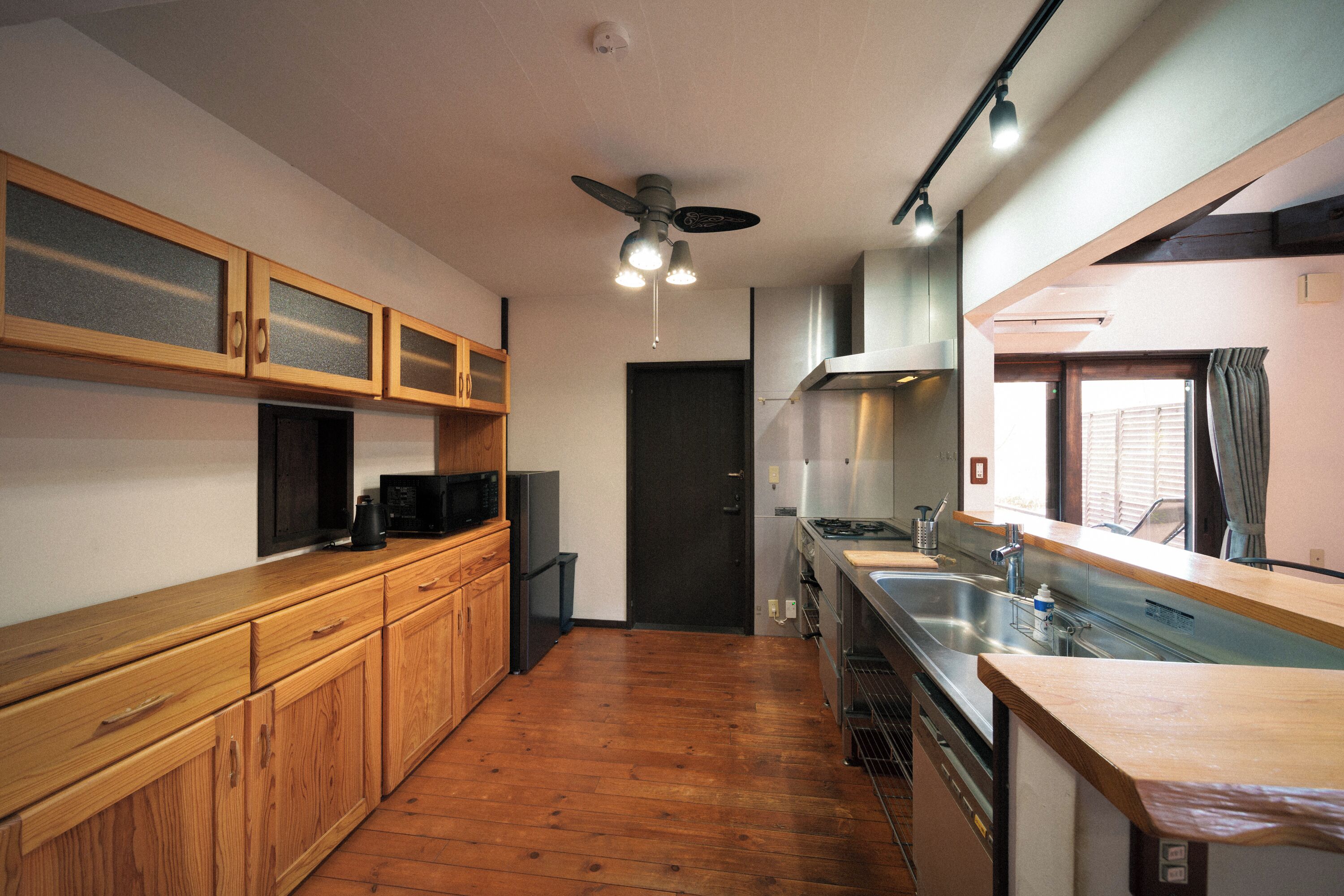 A kitchen with wooden cabinets, a microwave, a stove, and a sink.