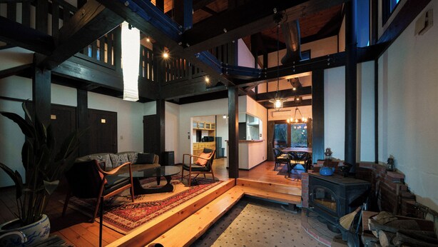 Una sala de estar acogedora con chimenea, vigas de madera y un comedor.