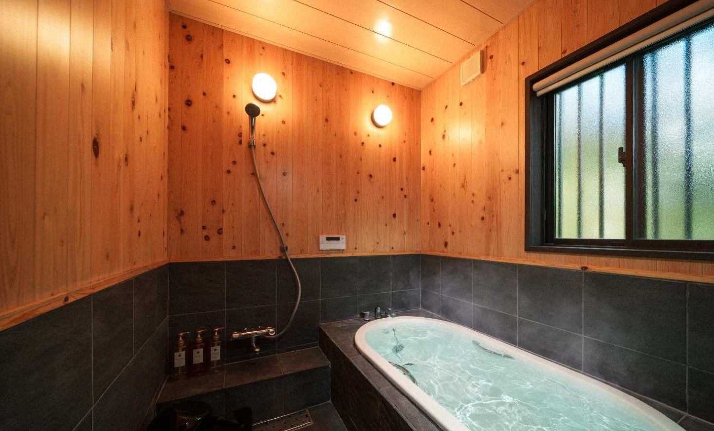 A wooden interior with a large bathtub and a shower area.
