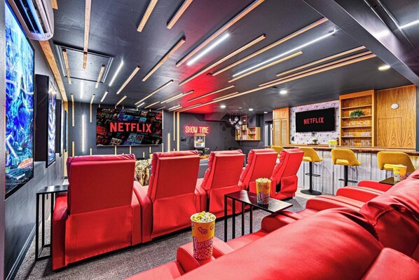 A modern cinema with red seating, a Netflix sign, and a bar area.
