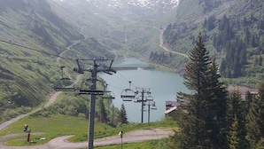 A mountain landscape with a lake, a ski lift, and a road leading to a building. - Renovated studio in Avoriaz center, perfect for 4 guests (Avoriaz)