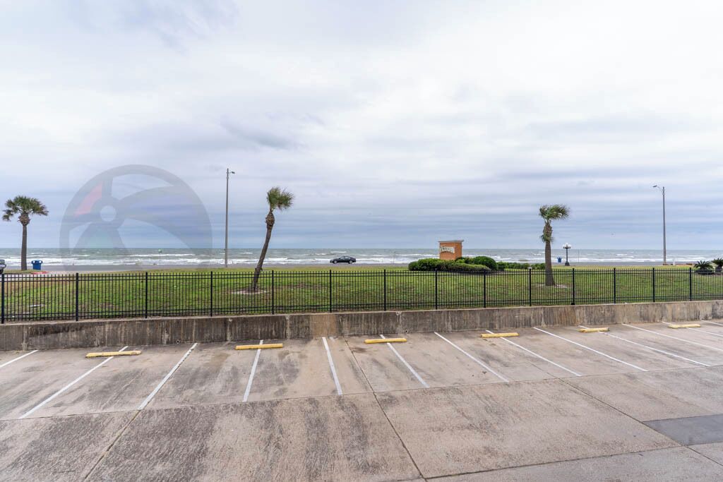 A parking area with a view of the ocean and a beach.