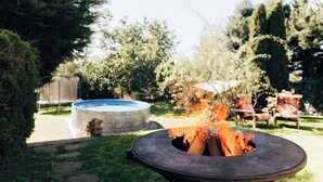 A backyard with a circular stone fire pit and a swimming pool. - DiamondVilla, 4 bedroom Apartment, garden & spa (Hlavní mesto Praha)