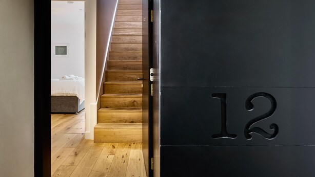 Una escalera conduce a un dormitorio con una cama y una mesita de noche.