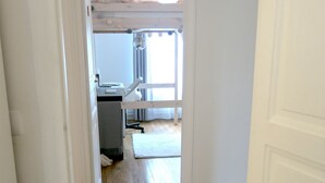 A hallway leading to a room with a bunk bed, a desk, and a window with curtains. - Appartement Village Daguerre Citycosy (Paris)