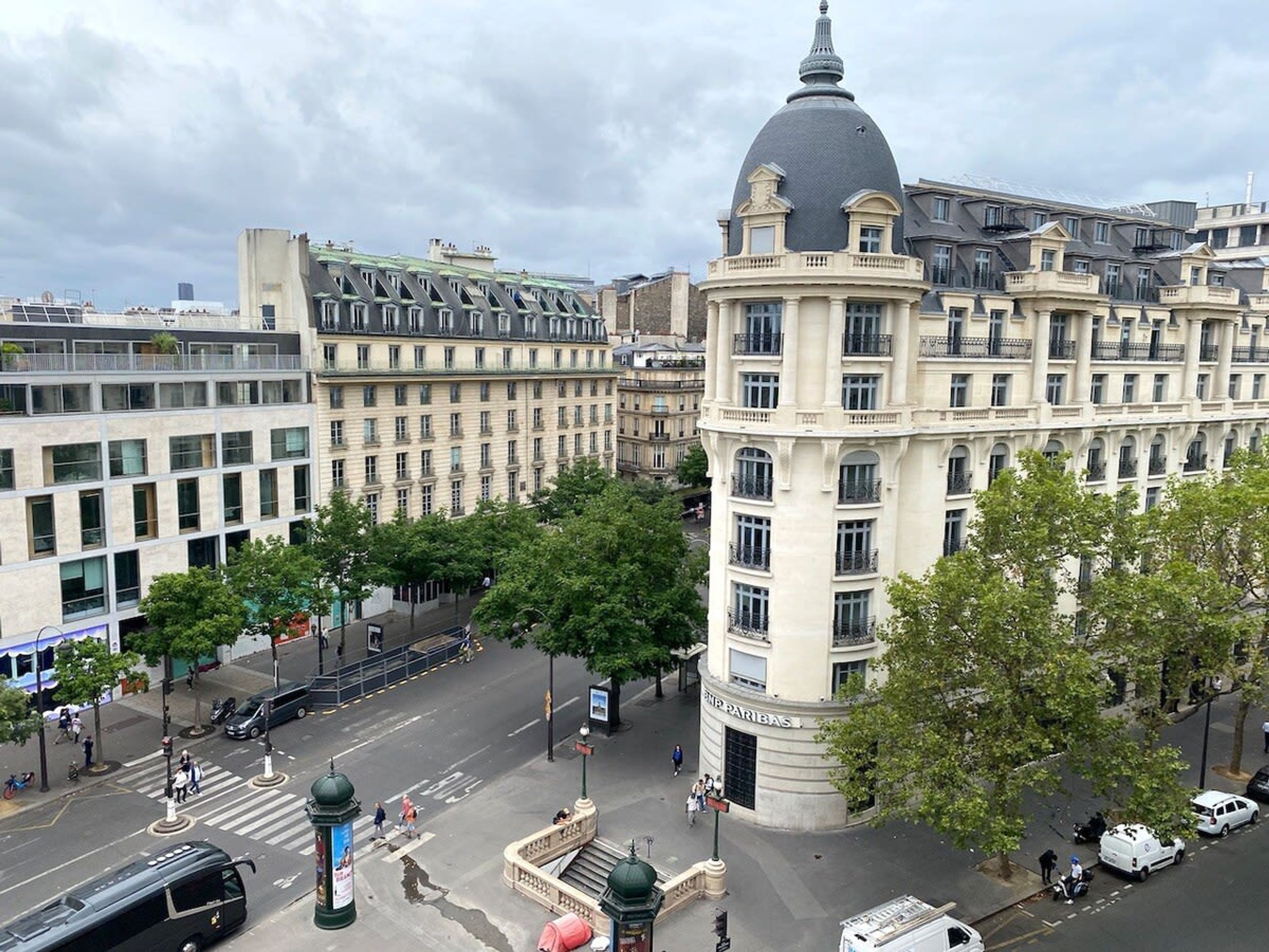 A historic building with a prominent dome and classical architecture, surrounded by modern buildings and a busy street scene.